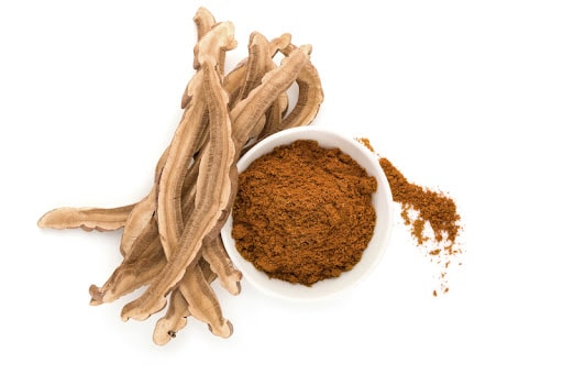 reishi mushroom root next to a white bowl of reishi powder